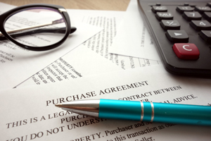 Purchase agreement with blue pen and calculator